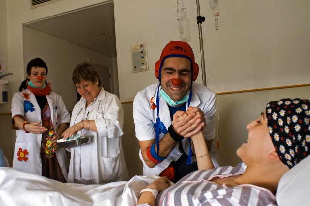 Hospital clowns joke with a cancer patient